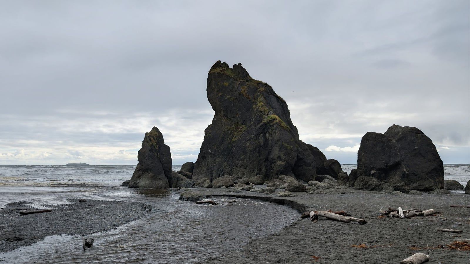 Sea stacks and driftwood border a stream flowing into the Pacific Ocean at Ruby Beach in Olympic National Park.